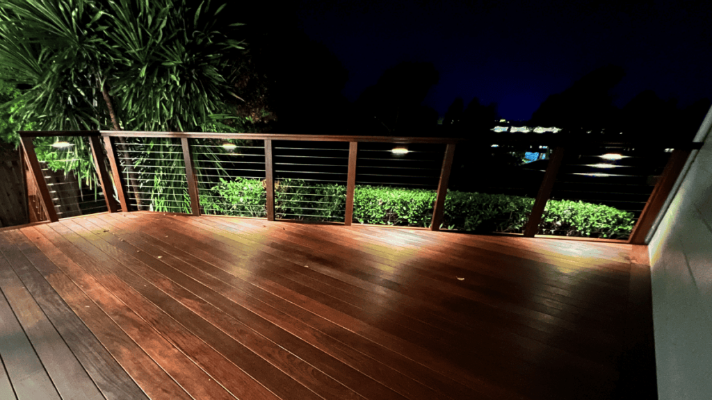 a deck with a railing and trees at night from Circlefoot